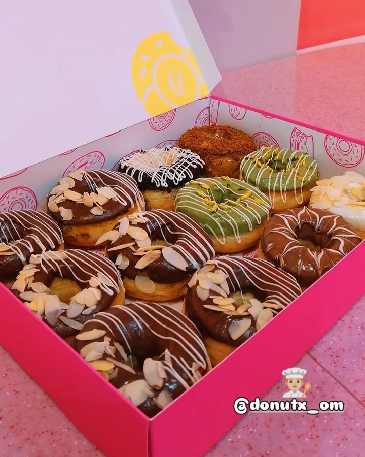 A box of Donut X donuts with almonds, pistachio and chocolate